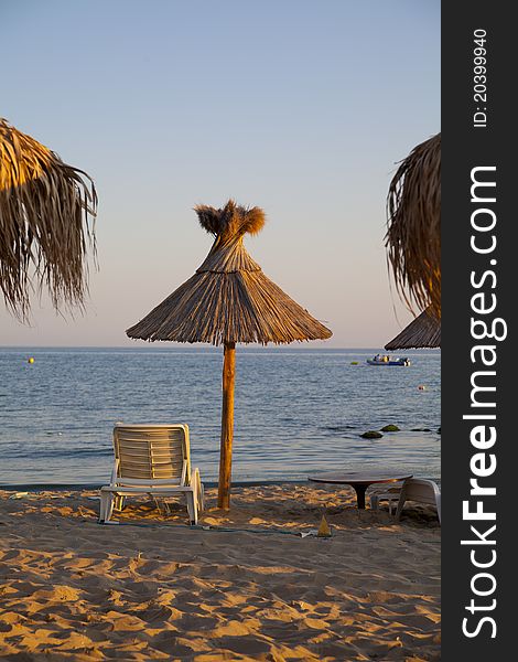 Beach with palms umbrella and chairs