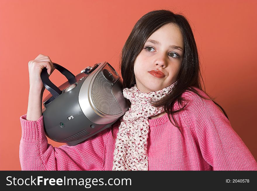 Pretty girl listening music and holding portable CD radio