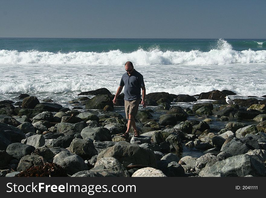 Man walking on the California coast line. Man walking on the California coast line