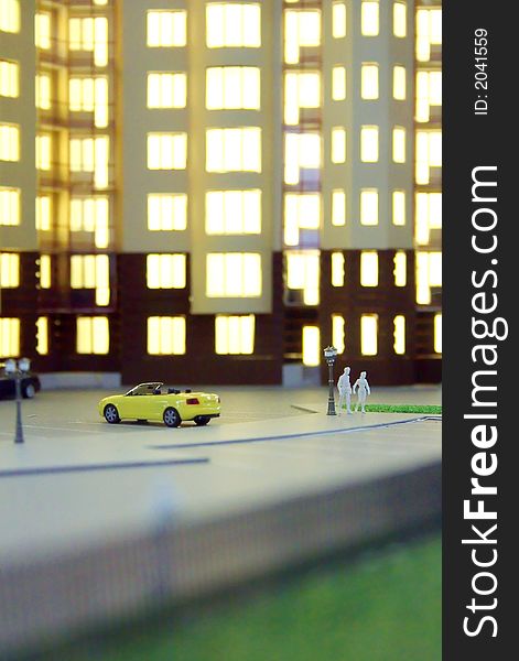 Model of a multi-storey apartment house with figures of people and car