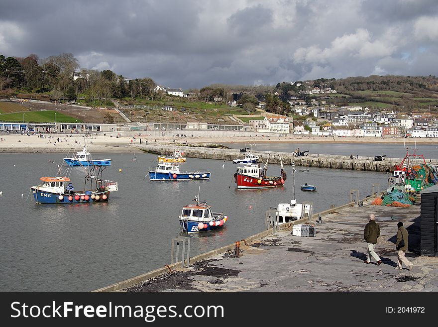 Fishing Boats in the Harbour in the  English Seaside Resort of Lyme Regis, with Stormy clouds in the background.