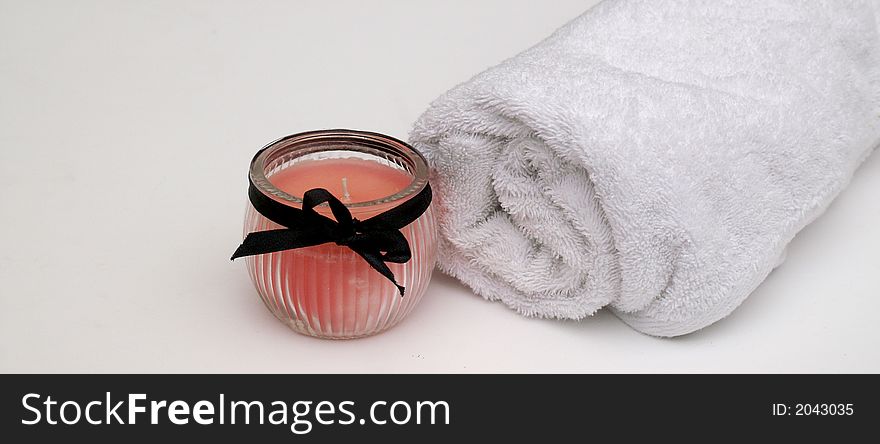 Relaxing pretty pink scented candle and crisp white bath towel for a soothing bath time. Relaxing pretty pink scented candle and crisp white bath towel for a soothing bath time