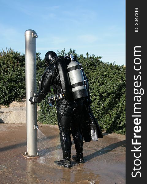 Scuba diver taking a shower. Scuba diver taking a shower