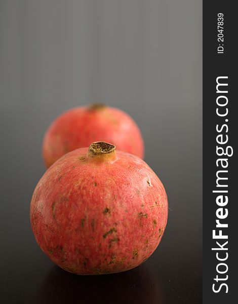 Whole Pomegrantes on a dark wooden table