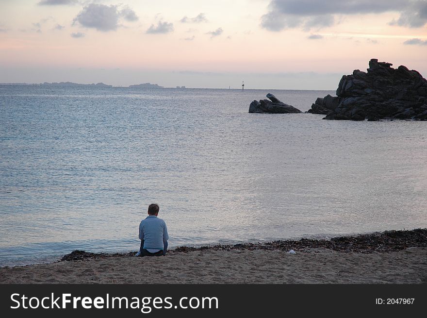 Woman sitting in full relax in front of sunset on the sea