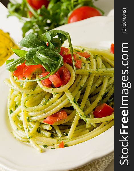 Photo of delicious pasta with arugula pesto and cherry tomatoes