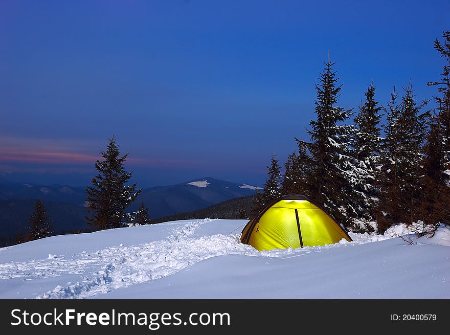 Evening in mountains in the winter with tourist tent. Evening in mountains in the winter with tourist tent