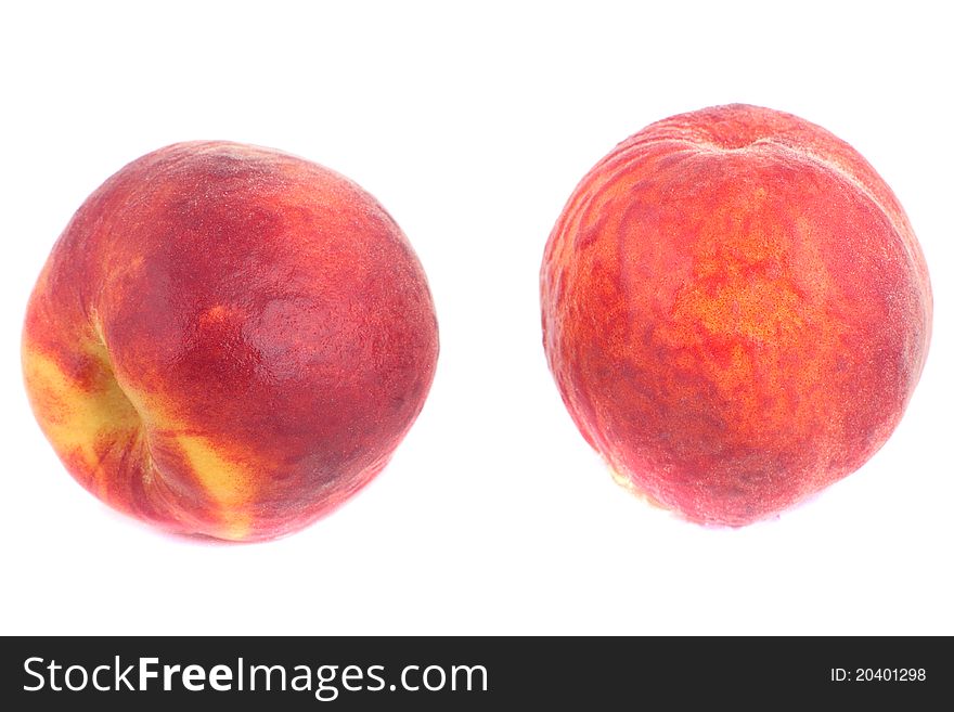 Two sweet peaches with water drops isolated on white background.