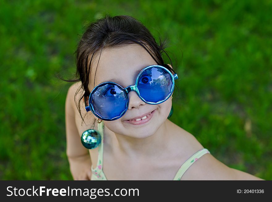 Little girl in funny glasses on outdoor