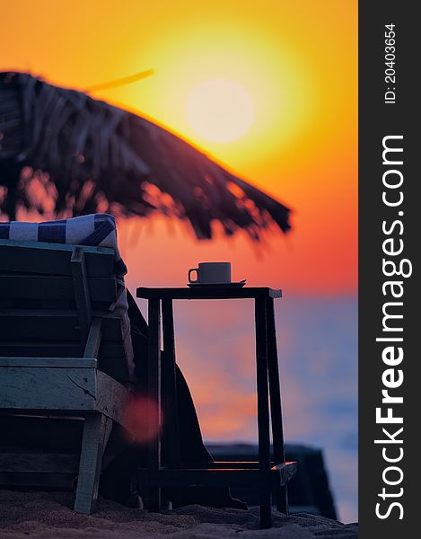 Exotic beach umbrella and deckchair on tropical coast on evening. Exotic beach umbrella and deckchair on tropical coast on evening