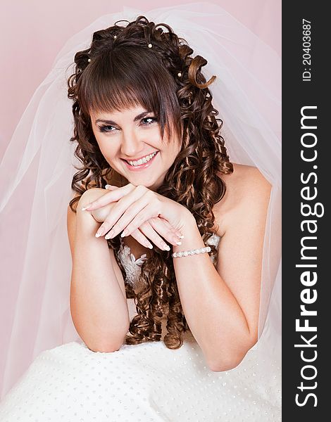 Studio portrait of a happy bride on a pink background
