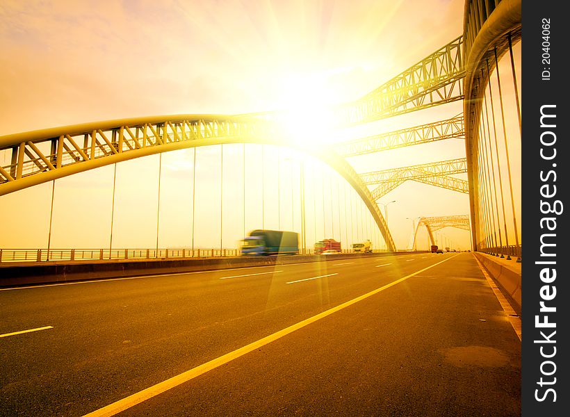 Road through the bridge with blue sky background of a city.