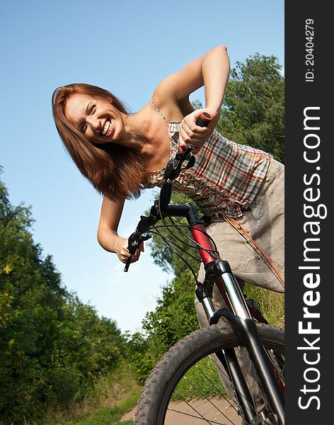 Pretty Young Woman With Bicycle In A Park Smiling