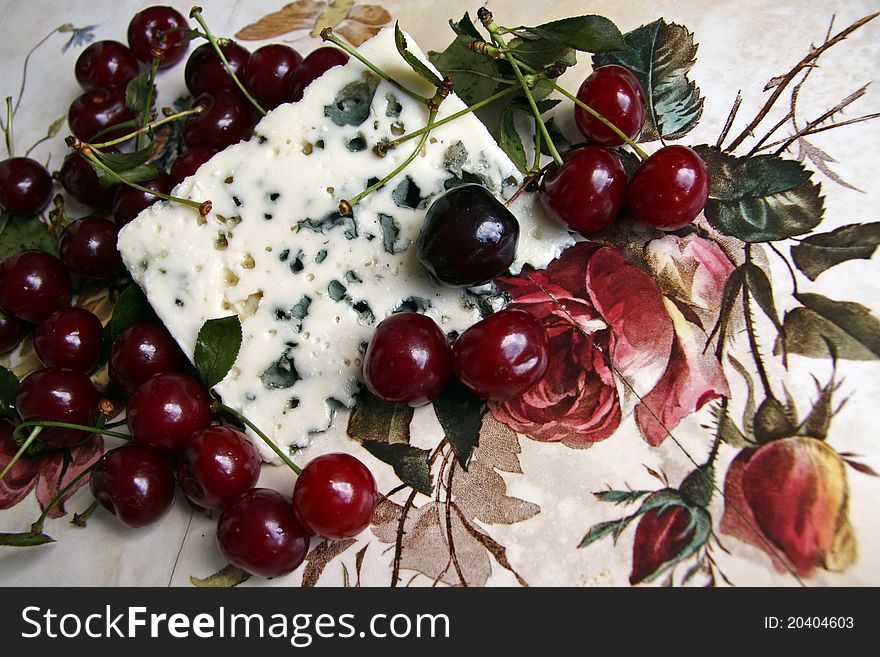 Red cherry and cheese with a blue mold. Red cherry and cheese with a blue mold