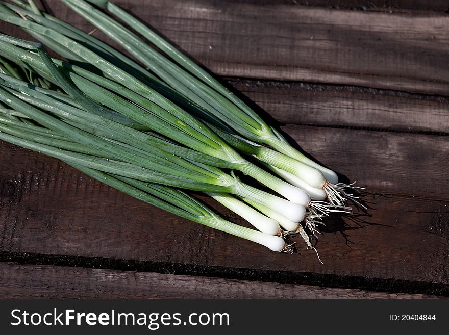 Scallions laying on a wooden table. Scallions laying on a wooden table.