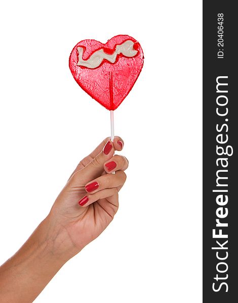 Heart shape lollipop in a hand isolated over white background