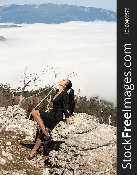 Woman in a raincoat standing near the cliff. Woman in a raincoat standing near the cliff