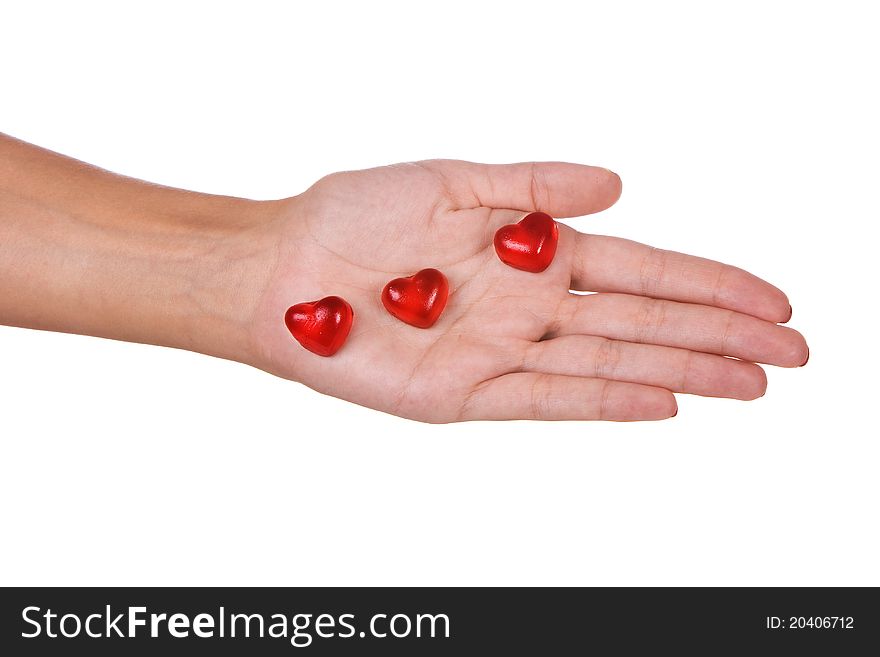 Heart shape candies in a hand isolated over white background