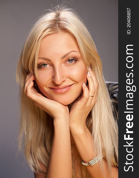 Young woman with beautiful blonde hair on a gray background. Young woman with beautiful blonde hair on a gray background