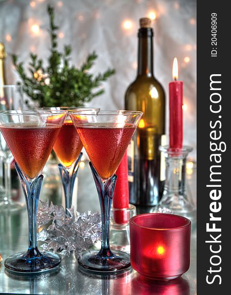 Red wine in glasses,red candle,bottles on silver backgroun with blurred lights. Red wine in glasses,red candle,bottles on silver backgroun with blurred lights.