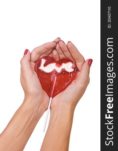 Heart shape lollipop in a hand isolated over white background