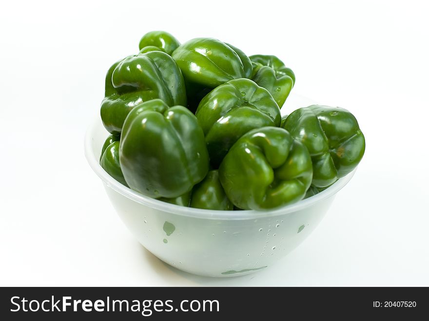 Green fresh peppers in the bowl on the white background. Green fresh peppers in the bowl on the white background