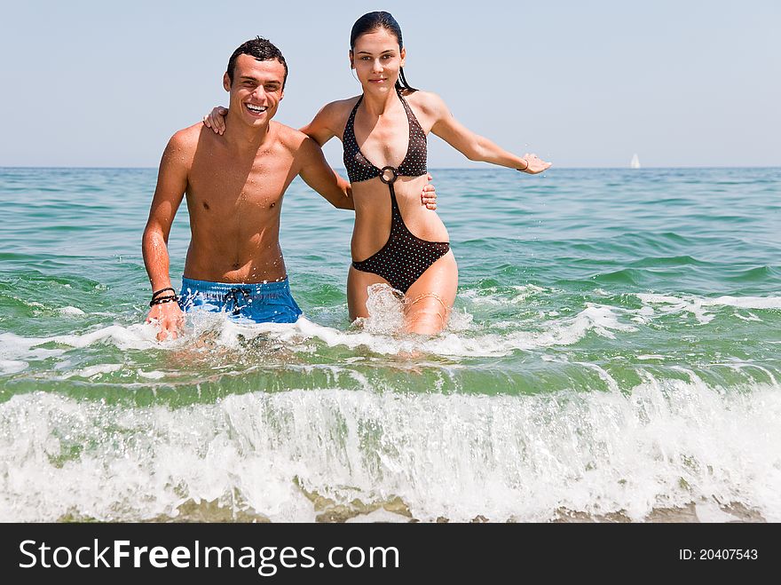 Young happy couple hugging going out of sea. Young happy couple hugging going out of sea