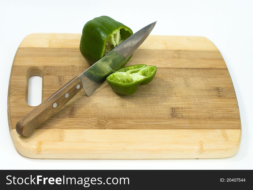 Green pepper cut with a knife on the white background. Green pepper cut with a knife on the white background
