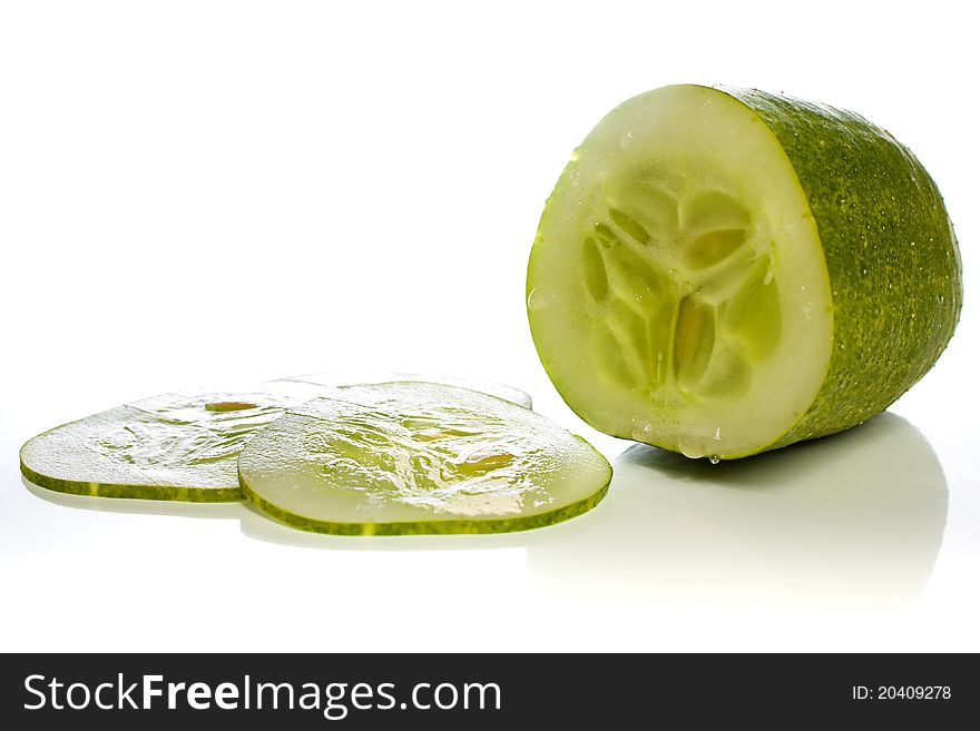 Cucumber and thin cucumber slices against a white background. Cucumber and thin cucumber slices against a white background