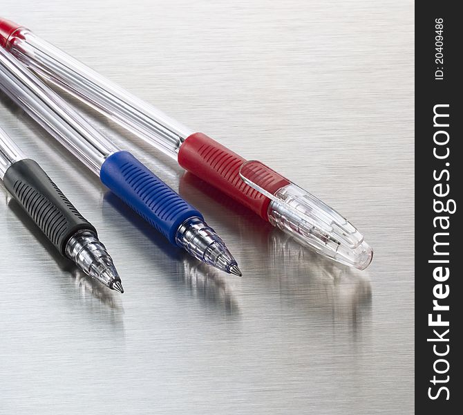 Pens, red, blue and black on stainless steel