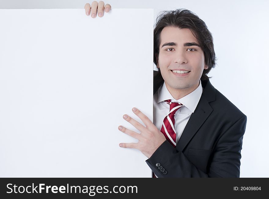 Young man appears from behind a white panel. Young man appears from behind a white panel