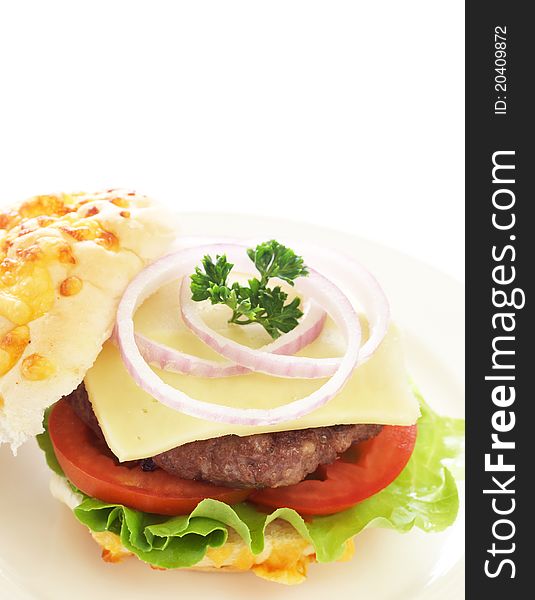 Tasty hamburger with grilled patty, tomato, cheese and lettuce on white cheese bun. Tasty hamburger with grilled patty, tomato, cheese and lettuce on white cheese bun