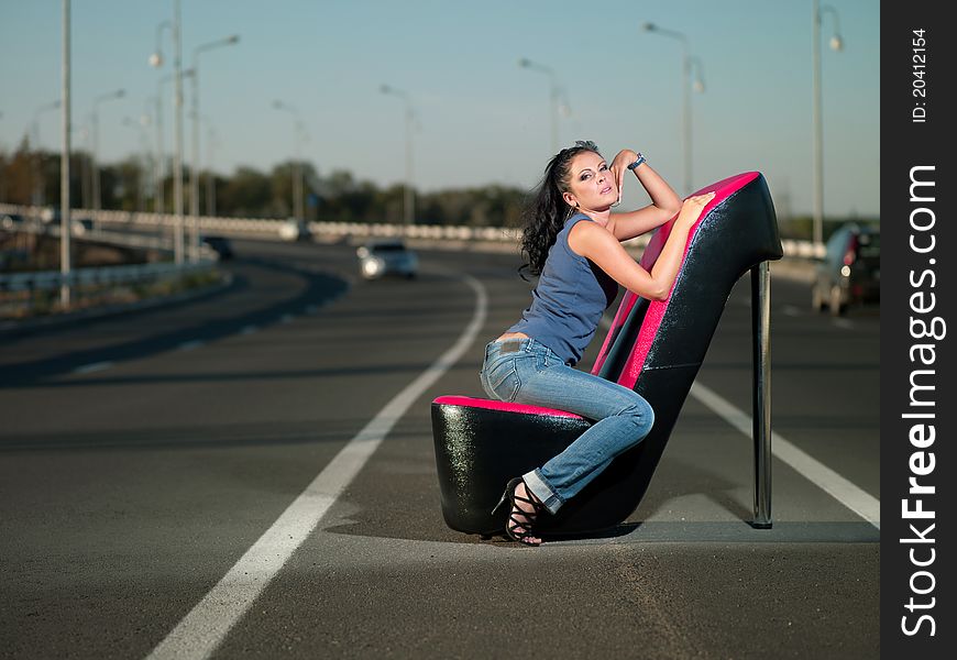 Woman sitting in an armchair on the highway. Woman sitting in an armchair on the highway