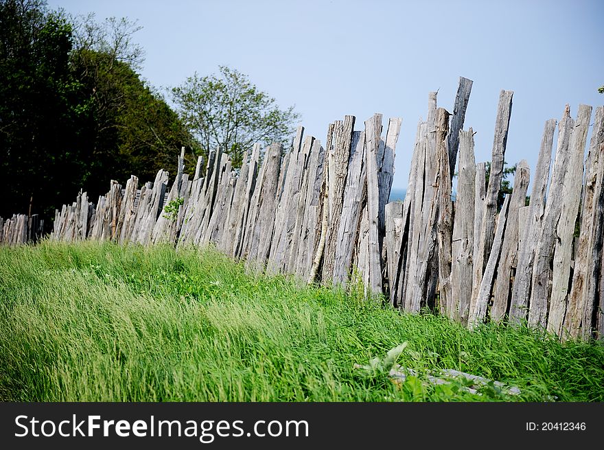 Old wooden fence on green meadow