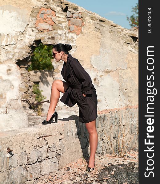 Woman standing near the destroyed wall. Woman standing near the destroyed wall