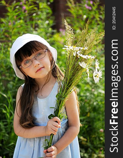 Cute girl in glasses with bouquet of grass and daisies. Cute girl in glasses with bouquet of grass and daisies