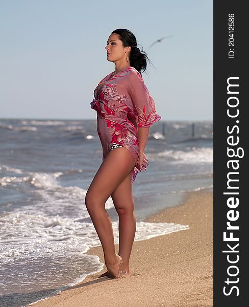 Woman in a bathing suit standing on the beach. Woman in a bathing suit standing on the beach