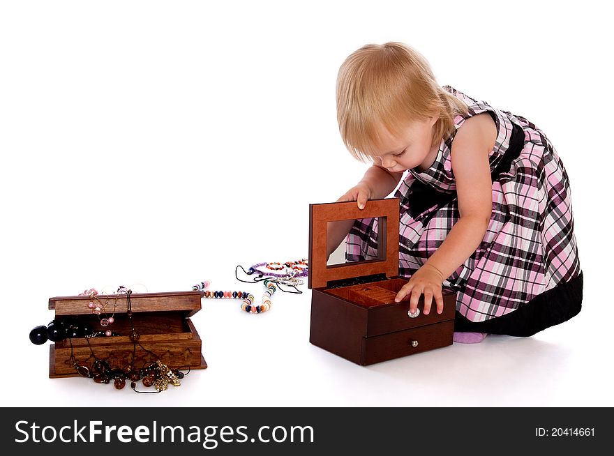 The little girl opens a box with a beads. The little girl opens a box with a beads