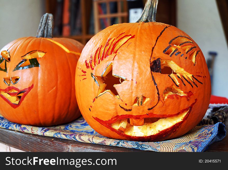 Two jack-O-lanterns sitting on a table. Two jack-O-lanterns sitting on a table
