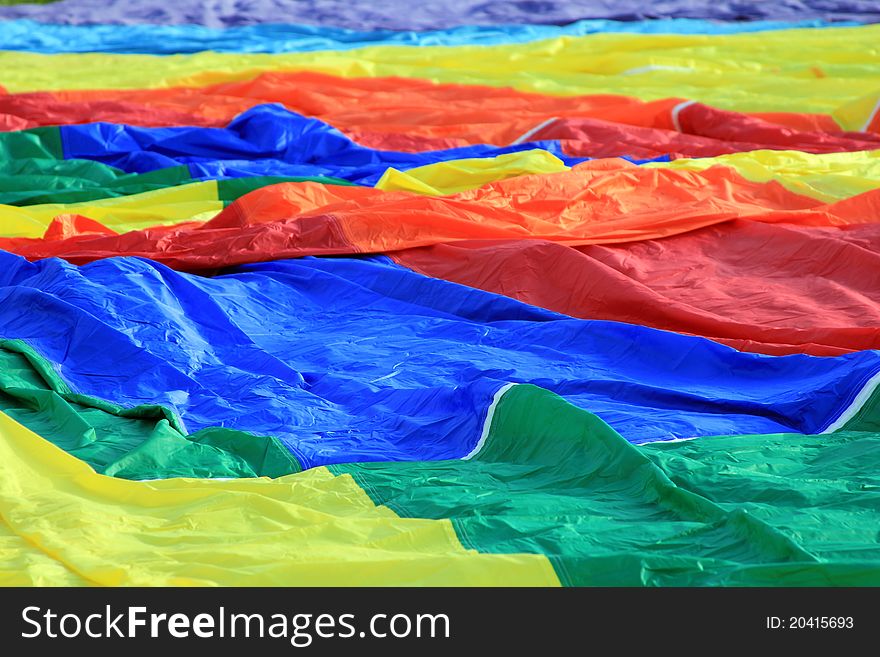 A colorful hot air balloon fabric waiting to be inflated. A colorful hot air balloon fabric waiting to be inflated.