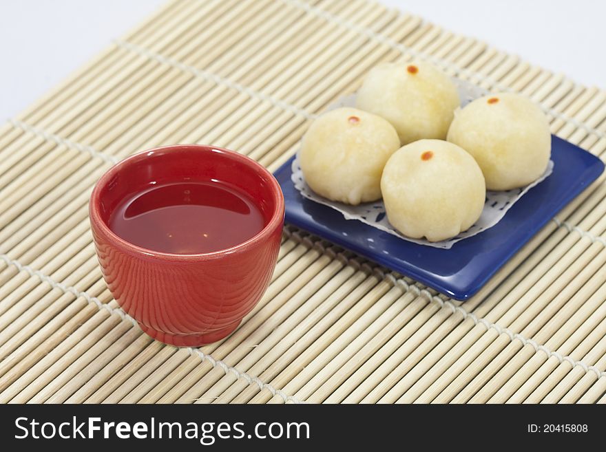 Chinese tea in red cup with chinese cake