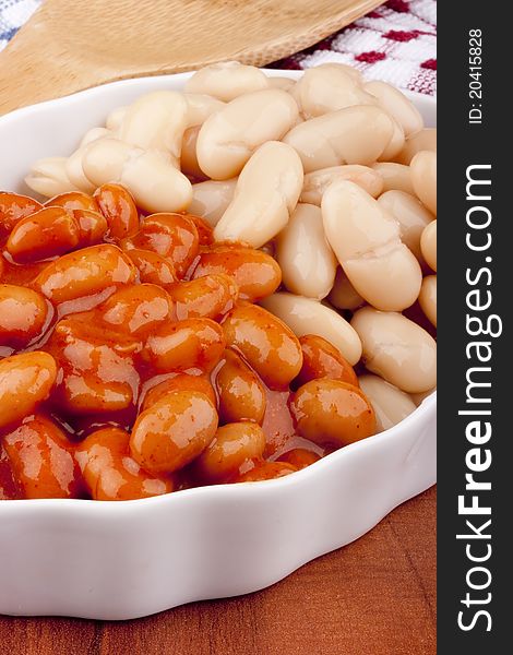 White canned beans in a white ceramic dish with red sauce. White canned beans in a white ceramic dish with red sauce.