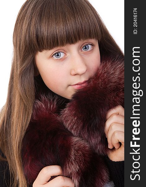 Beautiful young girl in a fur coat isolated on a white background