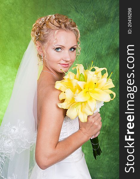 Portrait of a young beautiful bride with bouquet of lilys