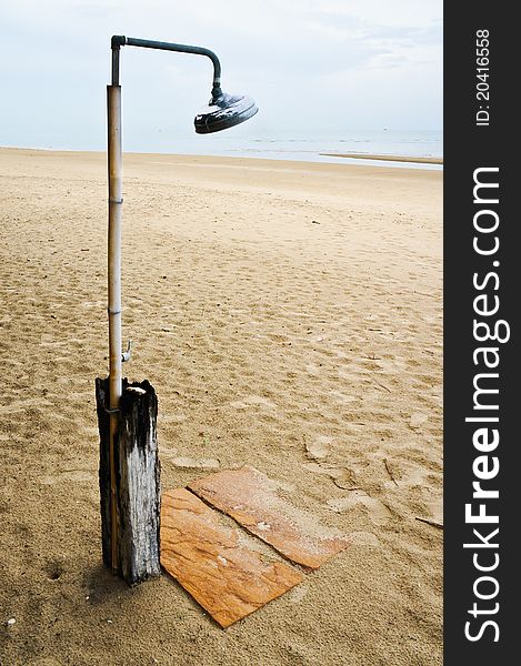 Shower on the beach with sand stone