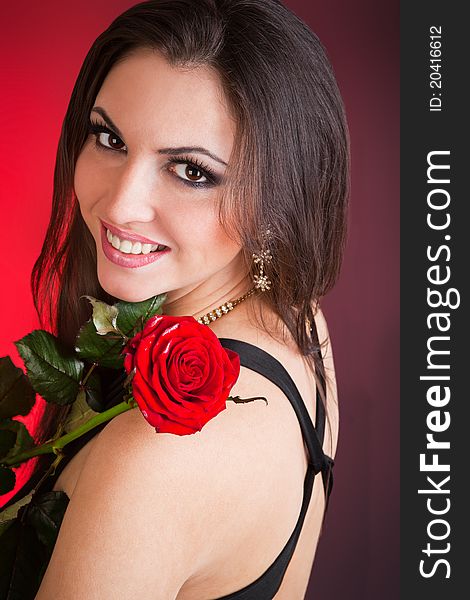 Portrait of young beautiful woman and red rose