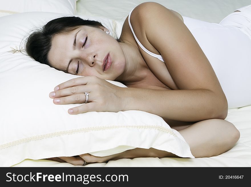 The beautiful young woman sleeps on white bed. The beautiful young woman sleeps on white bed