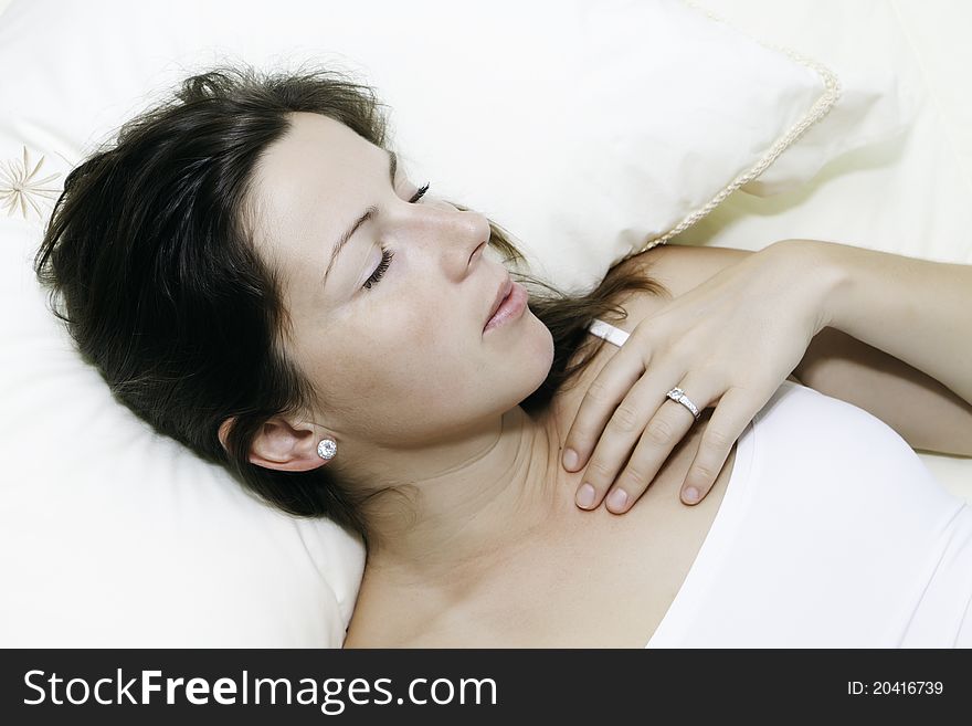 The beautiful young woman sleeps on white bed. The beautiful young woman sleeps on white bed