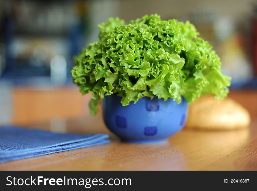An image of fresh leaves of lettuce in blue bowl