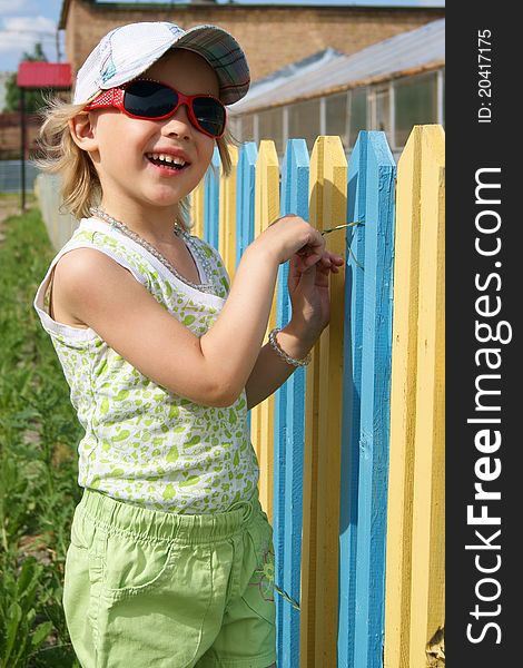 Smiling girl stands near a color fence. Smiling girl stands near a color fence